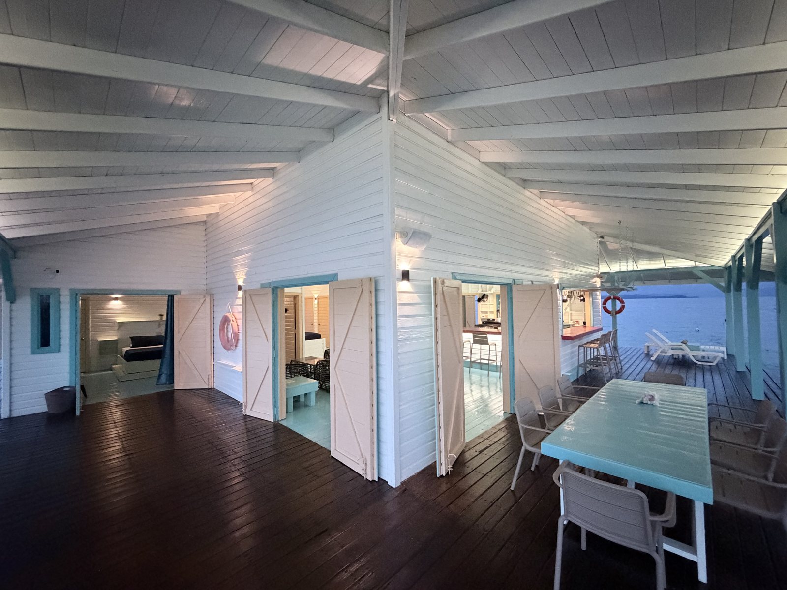Covered wraparound deck with open doors to the bedroom, living room and kitchen