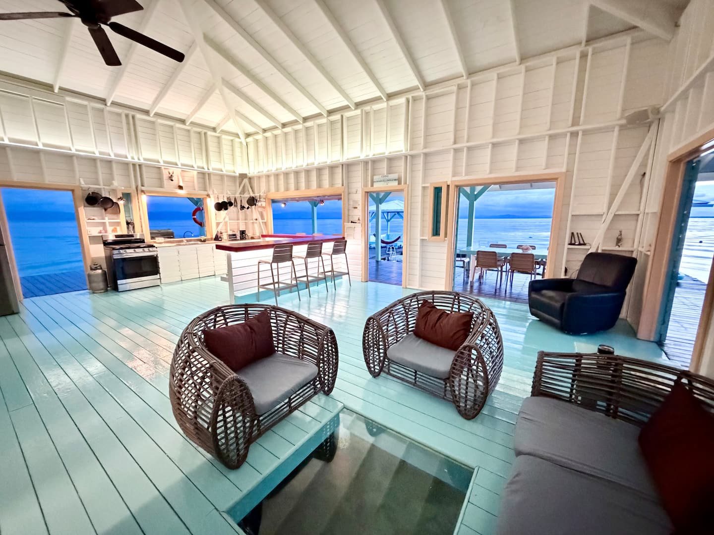 Bright open-plan living room at Casa Clearwater with wicker chairs and sea views